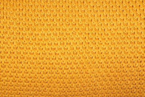 Texture of yellow knitted blanket as background, closeup