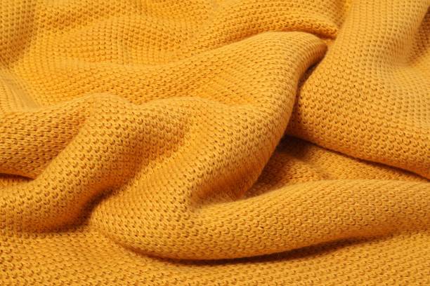 istock Texture of yellow knitted blanket as background, closeup 1955675310