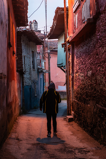 The man who goes to work before sunrise. he proceeding through narrow streets. photographed from behind. Shot with a full frame camera.