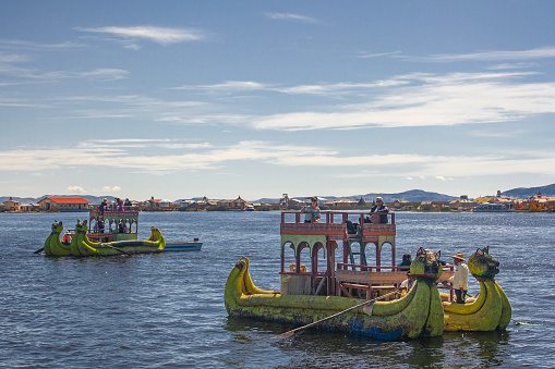 Uros, Peru - April 29, 2022: Tourist boats made of reed moored at Uros Islands, Lake Titicaca, Peru