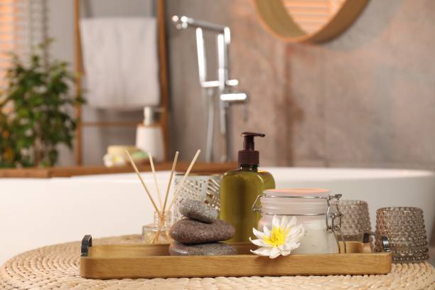 istock Different spa products and beautiful flower on wicker table in bathroom 1955688567