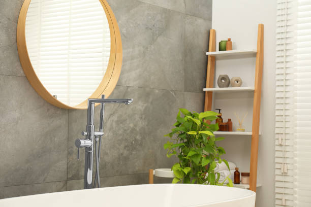 istock Spa day. Stylish bathroom interior with ceramic tub mirror and green houseplant 1955690708