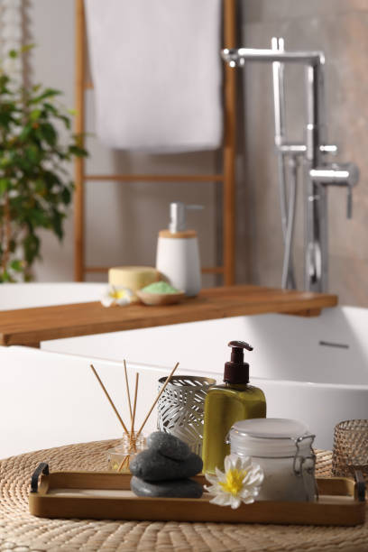 istock Different spa products and beautiful flower on wicker table in bathroom. Space for text 1955692811