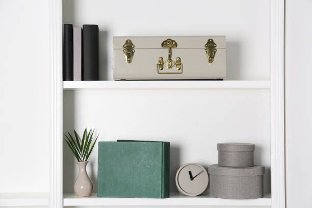 istock White shelves with clock, books and different decor indoors. Interior design 1955693860