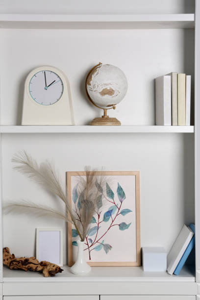 istock White shelves with books, globe and different decor indoors. Interior design 1955694368