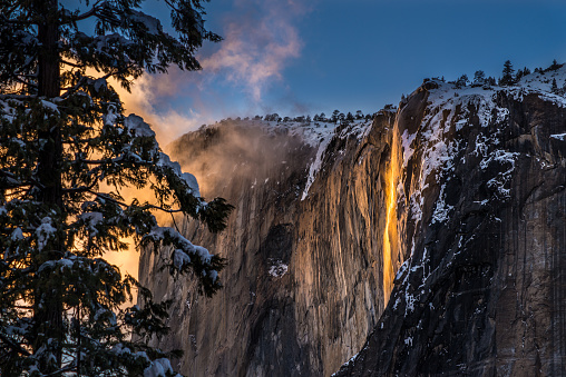 In the crisp embrace of February, this awe-inspiring photograph immortalizes the breathtaking spectacle of Yosemite's legendary firefall. As the sun dips below the horizon, a cascading ribbon of molten hues ignites the granite cliffs, casting the entire landscape aglow. The juxtaposition of wintry surroundings with the vivid, fiery cascade creates a mesmerizing portrait of nature at its most dramatic and enchanting, offering a fleeting glimpse of a truly magical moment.