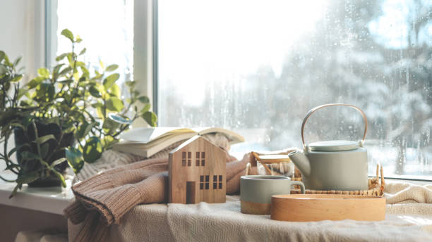istock Cozy winter photo, stack of sweaters, book, tea and candle 1955732432