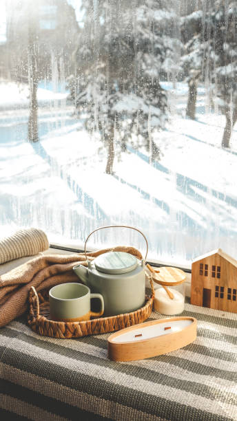 istock Cozy winter home interior, candle, tea and teapot on the windowsill 1955732435