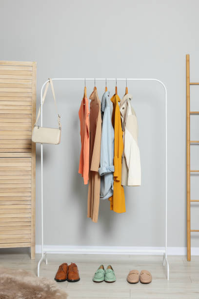 istock Stylish room interior with clothes rack and folding screen 1955755704