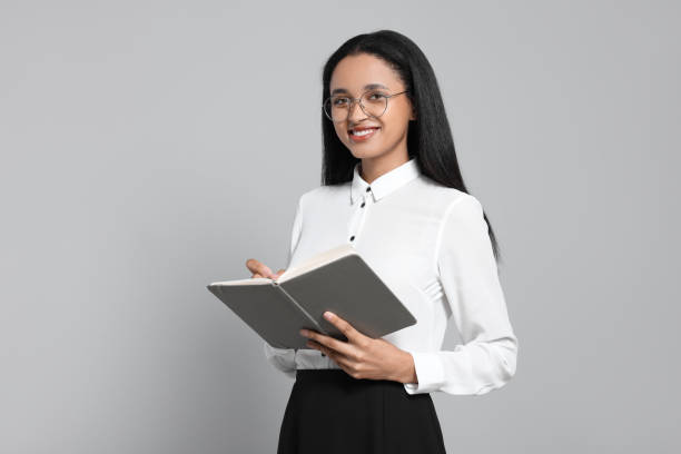 istock Beautiful secretary with notebook on light gray background 1955768248