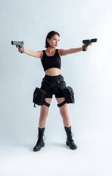 istock Asian woman holding two guns 1955768764