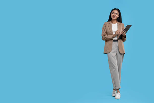 istock Beautiful secretary with clipboard and pen on light blue background, space for text 1955770320