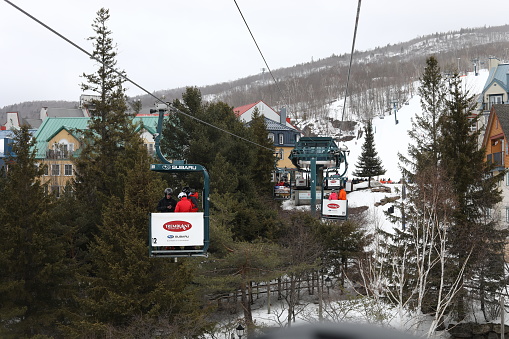 March 14, 2023 - Mont-Tremblant, Quebec, Canada: Views of the Mont-Temblant Ski Resort from a gondola (Cabriolet). People riding a cabriolet gondola on a ski resort to get to the base of the mountain. March Break in Mont-Tremblant. Skiing and snowboarding in Quebec, Canada. Mont-Tremblant Ski Resort in March 2023.