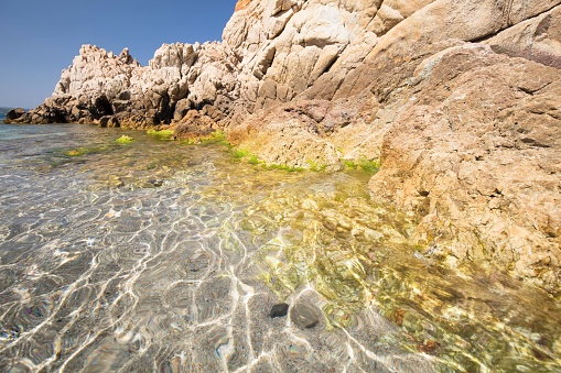 The wondrous and colorful waters of the Mediterranean sea on a summer day, on Monti Russu beach in Santa Teresa Gallura, in front of  Bonifacio Strait.