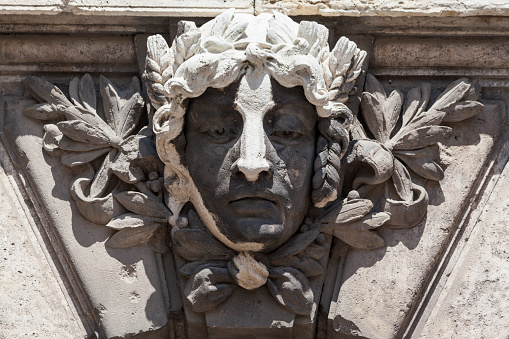 Man mask on the facade of the large palace Buda Castle\nBudapest, Hungary