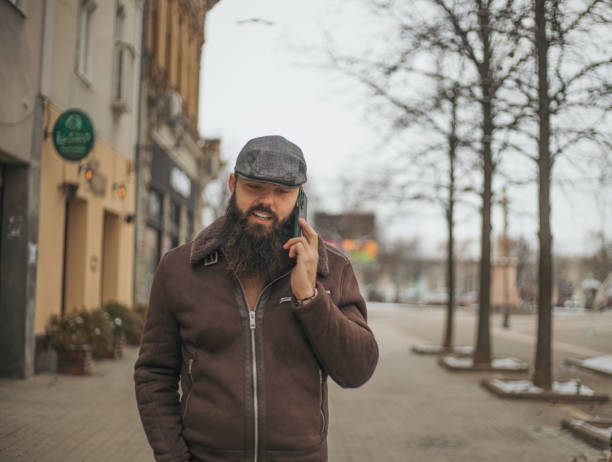 istock handsome hipster guy talking on the phone 1955796013