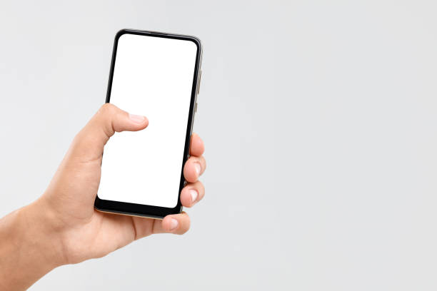 istock Man holding smartphone with blank screen on light grey background, closeup. Mockup for design 1955798216