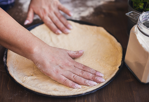 Woman kneading dough for homemade pizza