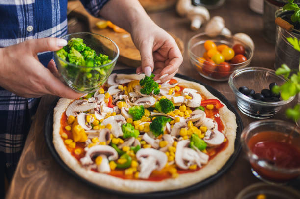 Women making a vegetarian pizza at home