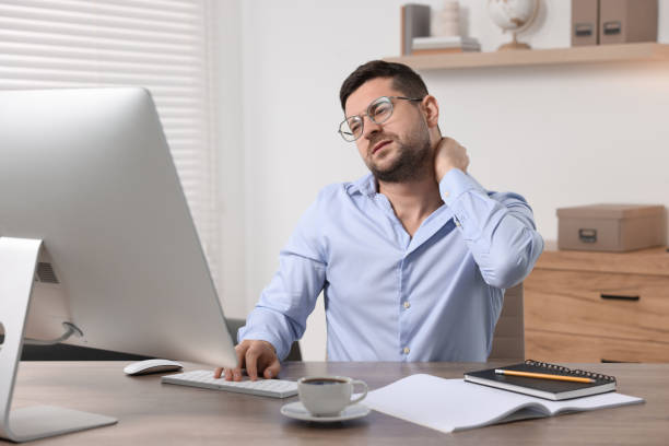 istock Man suffering from neck pain in office 1955822929