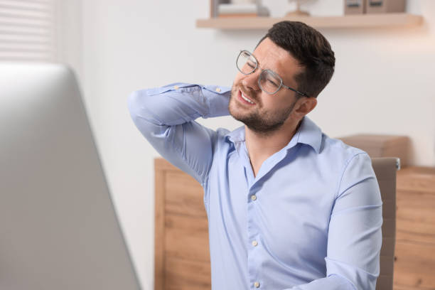 istock Man suffering from neck pain in office 1955823333