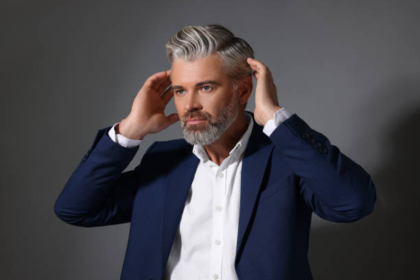 istock Portrait of confident man with beautiful hairstyle on dark grey background 1955832425