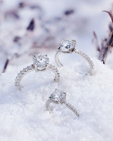 A trio of dazzling diamond rings beautifully contrast against a pristine snowy backdrop.