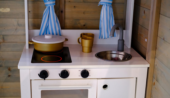 A toy kitchen with a sink and pans.