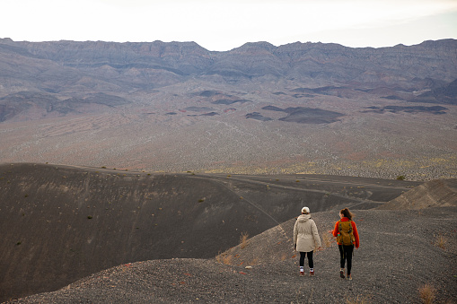 Captured on the rim of Ubehebe Crater in Death Valley National Park, two young woman walking along the edge of this ancient volcanic field