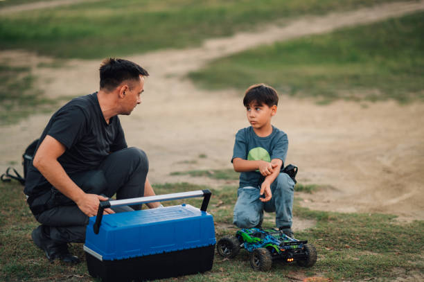 istock Boy feels guilty for breaking his toy car while father is trying to fix it 1955876600