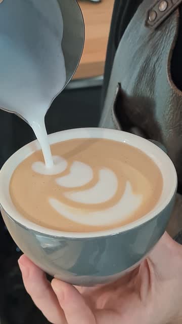 Barista making of cafe latte art, vertical video. High quality mobile footage