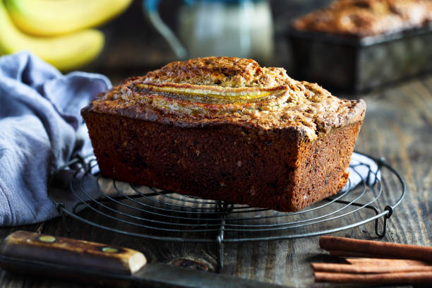 Whole Fresh Banana Bread Cooling on Bakers Rack with Ingredients