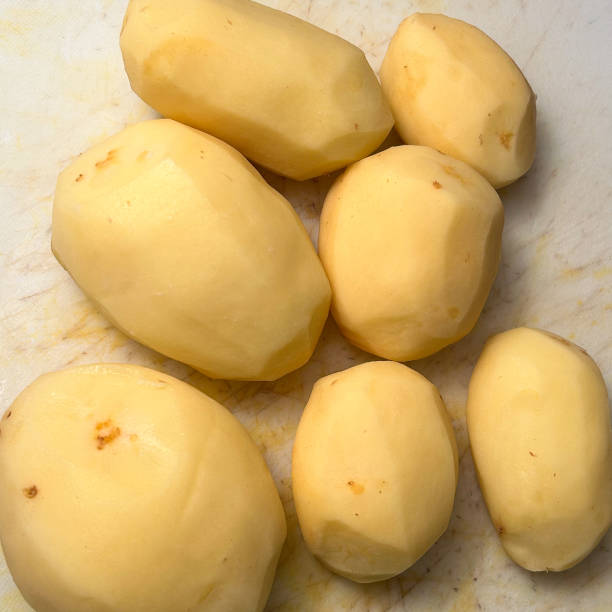 istock Whole pleeded potatoes on a cutting board 1955918967