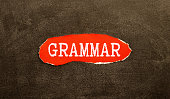 the word grammar wooden cubes with burnt letters, study of grammar of different languages, gray background top view,