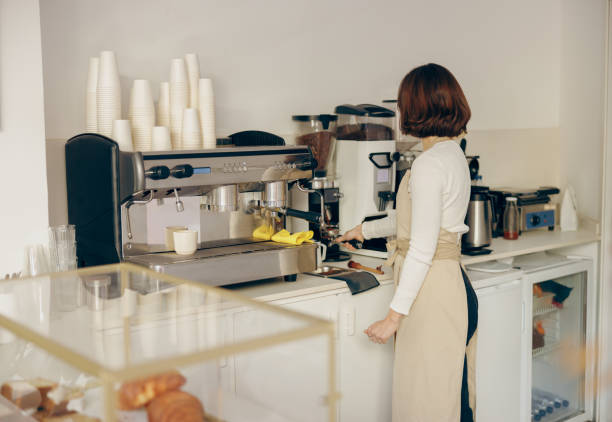 istock Professional female barista grind coffee bean with grinder machine while working in cafe 1955928746