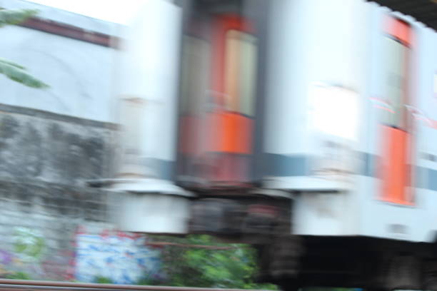 A high-speed train speeds through a train station. A speeding passenger train on a railroad platform. A train with motion blur effect