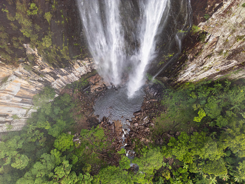 Top down drone view of waterfall flowing over cliff into subtropical rainforest at Minyon Falls near Byron Bay, Australia