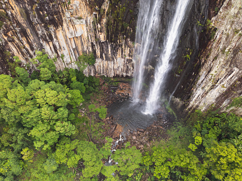 Top down drone view of waterfall flowing over cliff into subtropical rainforest at Minyon Falls near Byron Bay, Australia