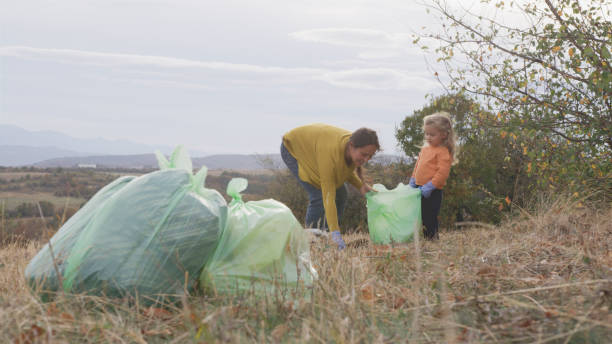 istock Nature cleanup with kid. Family collecting garbage. 1956104510