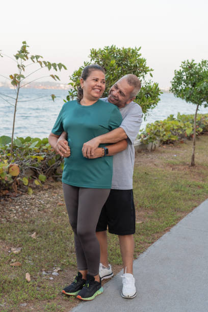 istock Senior Couple Embracing on Park Walkway 1956124983