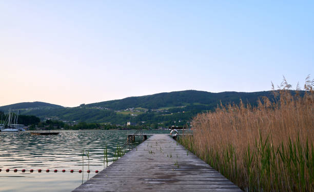 lake mondsee in alps mountains, austria. beautiful sunset landscape, with boats and pier. - seepromenade fotografías e imágenes de stock