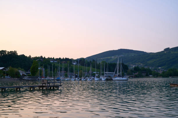 lake mondsee in alps mountains, austria. beautiful sunset landscape, with boats and pier. - seepromenade imagens e fotografias de stock