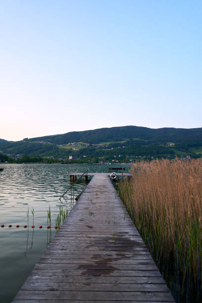 lake mondsee in alps mountains, austria. beautiful sunset landscape, with boats and pier. - seepromenade fotografías e imágenes de stock