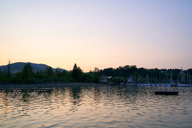 lake mondsee in alps mountains, austria. beautiful sunset landscape, with boats and pier. - seepromenade fotografías e imágenes de stock