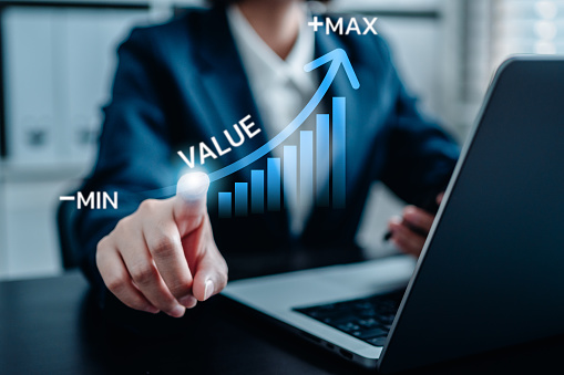 Businesswomen pointing virtual value arrow graph raises for business and profit to benefit growth organization, the business added value, potential skill labor, stock valuation.