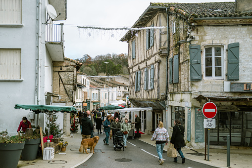 December 23, 2023, Montcuq, France:Locals and tourists enjoying food and drinks and buying local produce at the weekend market. Street markets in Montcuq are held every weekend. Local people and tourists come along to buy local produce on the bustling stalls.Montcuq  is a town and former commune in the Lot department in south-western France near Cahors.