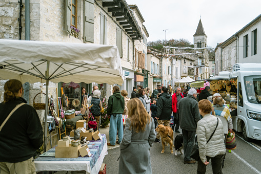 December 23, 2023, Montcuq, France:Locals and tourists enjoying food and drinks and buying local produce at the weekend market. Street markets in Montcuq are held every weekend. Local people and tourists come along to buy local produce on the bustling stalls.Montcuq  is a town and former commune in the Lot department in south-western France near Cahors.