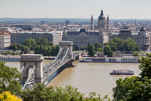 Budapest, Hungary. June, 19 - 2023: Chain Bridge crossing over the Danube river towards St Stephen cathedral.\nBudapest, Hungary