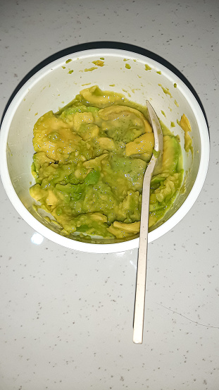 a bowl of real avocado pulp by cutting or separating directly from the skin and seeds of the fruit. Avocado (Persea americana) is a monoculture plantation crop and a garden plant