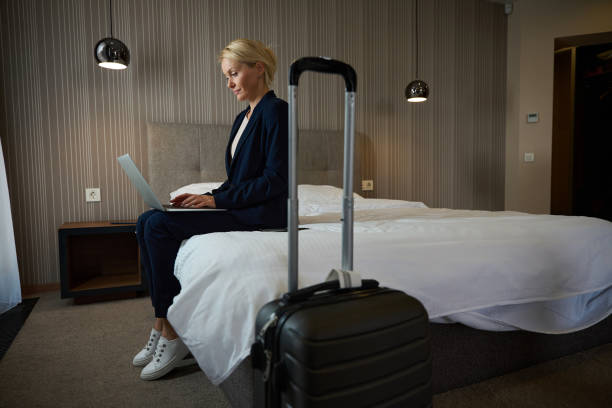 istock Business lady working on portable computer in hotel room upon arrival 1956280718